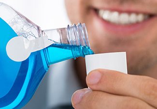 man pouring mouthwash