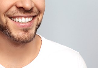 Man smiling in front of gray background