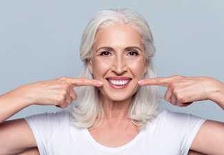 Woman pointing to her beautiful smile