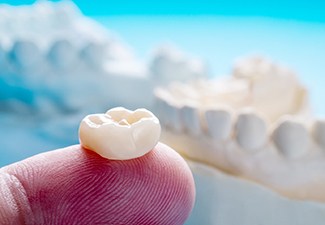 Close-up of dental crown in Leawood, KS on finger