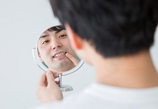 man checking smile in mirror
