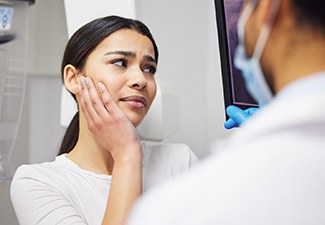 a patient explaining her oral pain to an emergency dentist