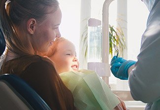 child sitting with mother in exam chair