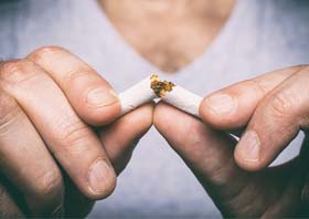 patient breaking cigarette in half