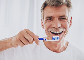 man brushing teeth in bathroom