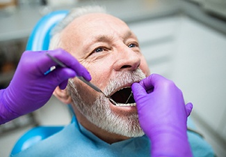 Implant dentist in Leawood performing exam on a patient