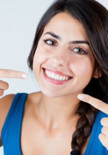 Woman rubbing her toothache and explaining symptoms to her dentist