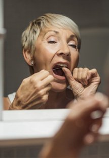 Dentist comparing dental veneer shades to patient’s smile
