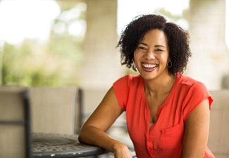 person leaning against a table and smiling