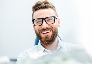 man smiling wearing black glasses