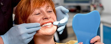 woman smiling in mirror checking smile