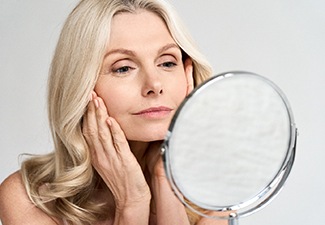 Woman looking in mirror, admiring results of SmoothLase
