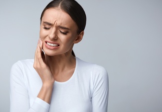 Distressed woman touching her cheek 