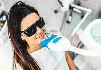 woman getting whitening treatment with glasses
