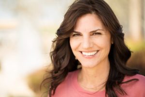 Woman smiling outside after visiting the dentist in Leawood