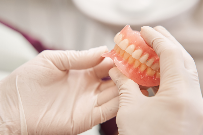 Dentist holding dentures